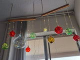 Colorful hanging glass ornaments with string lights on a ceiling