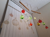 Decorative hanging mobile with colorful balls and lights against a neutral background